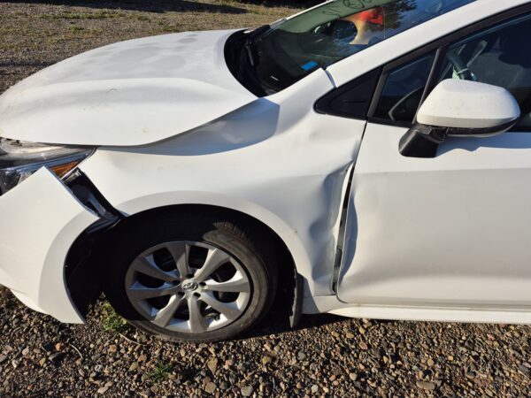damaged-white-toyota-corolla-driver-side-profile